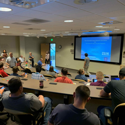 People sitting in a seminar at INIL watching a presentation on a screen